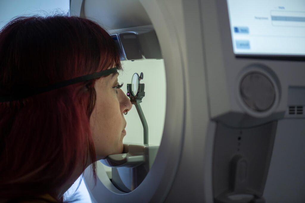 Girl looking in Optical Coherance Tomogropher machine