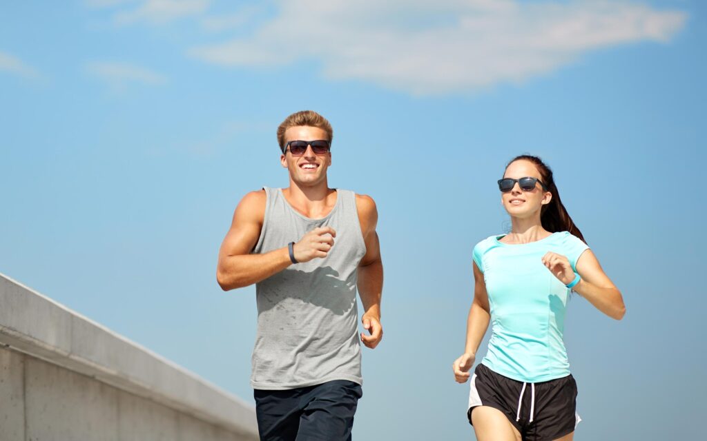 Sporty couple running in sunglasses
